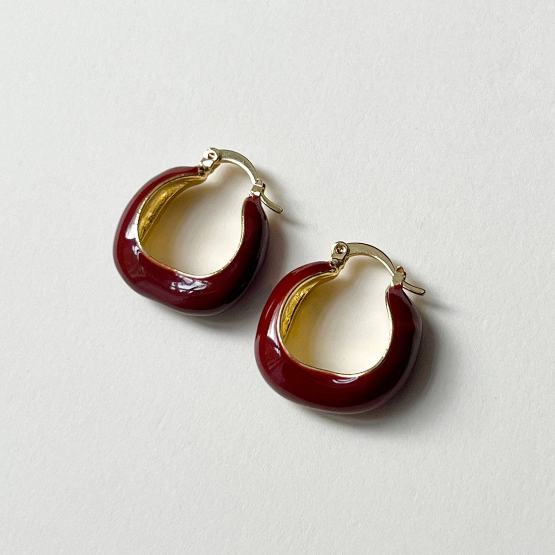 Aros elegantes de esmalte rojo vino