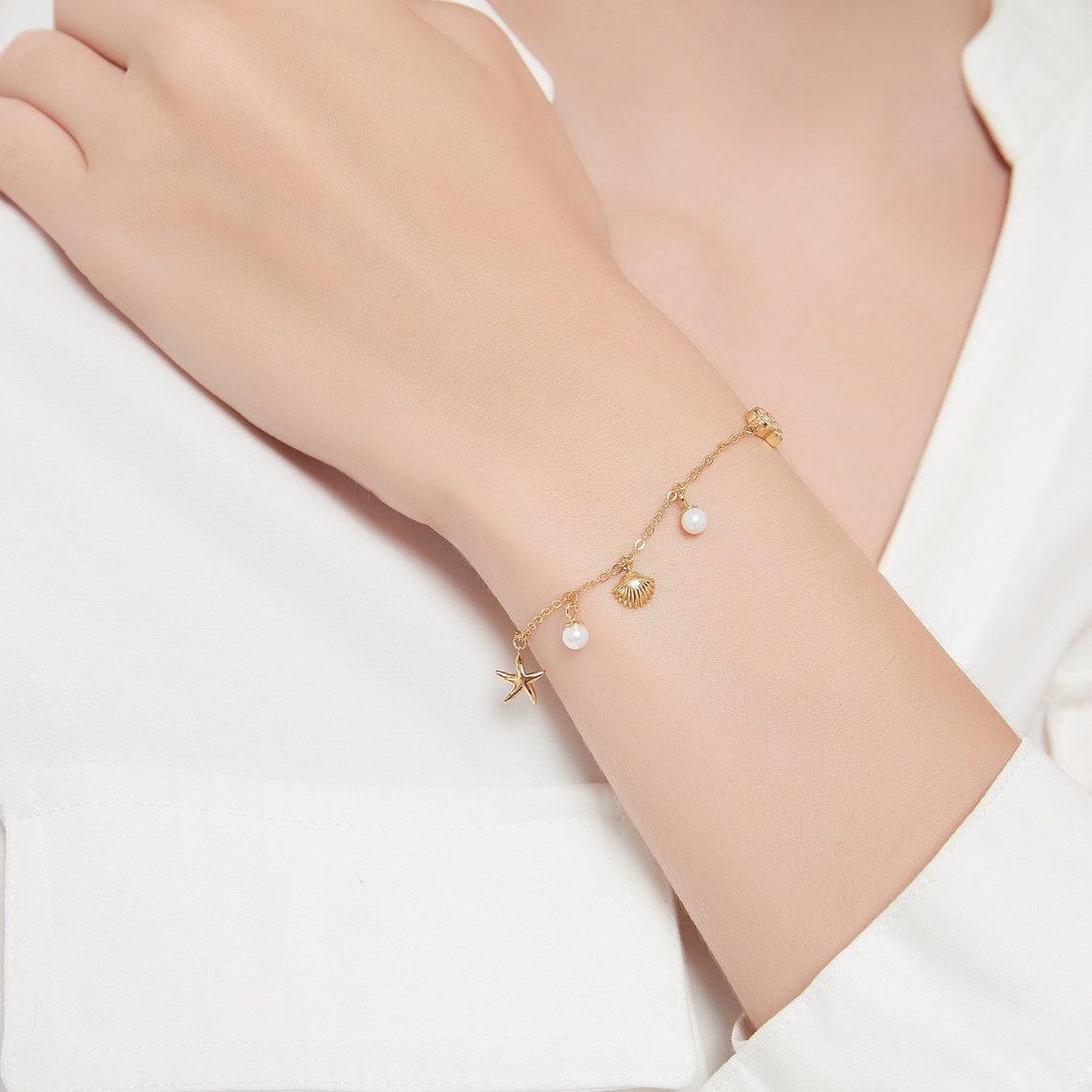Pulsera con colgante de concha y estrella de mar