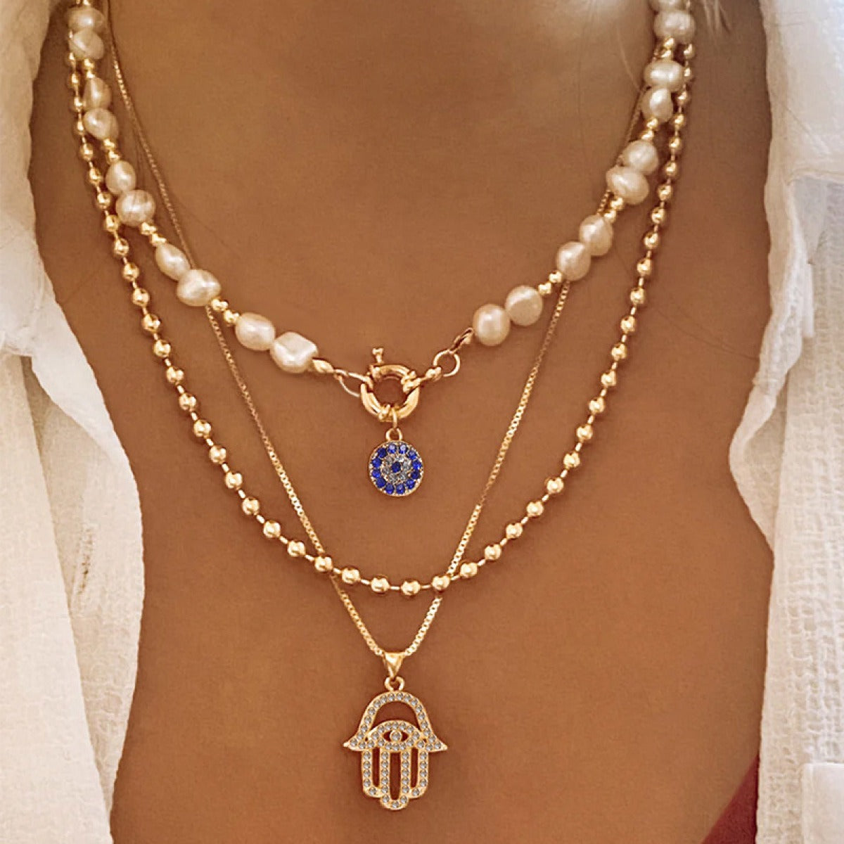 Jade – Collar de perlas en distintos niveles y Hamsa