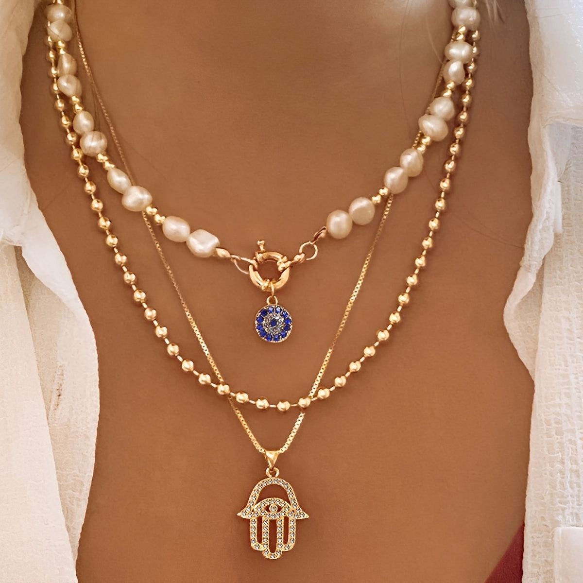 Nadia – Collar con múltiples filas de perlas y mano de Hamsa