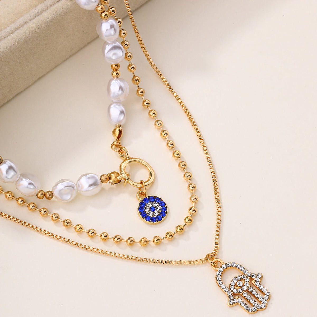 Jade – Collar de perlas en distintos niveles y Hamsa