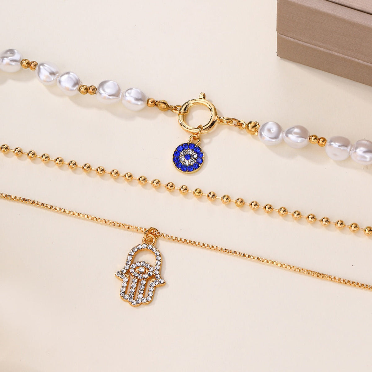Jade – Collar de perlas en distintos niveles y Hamsa