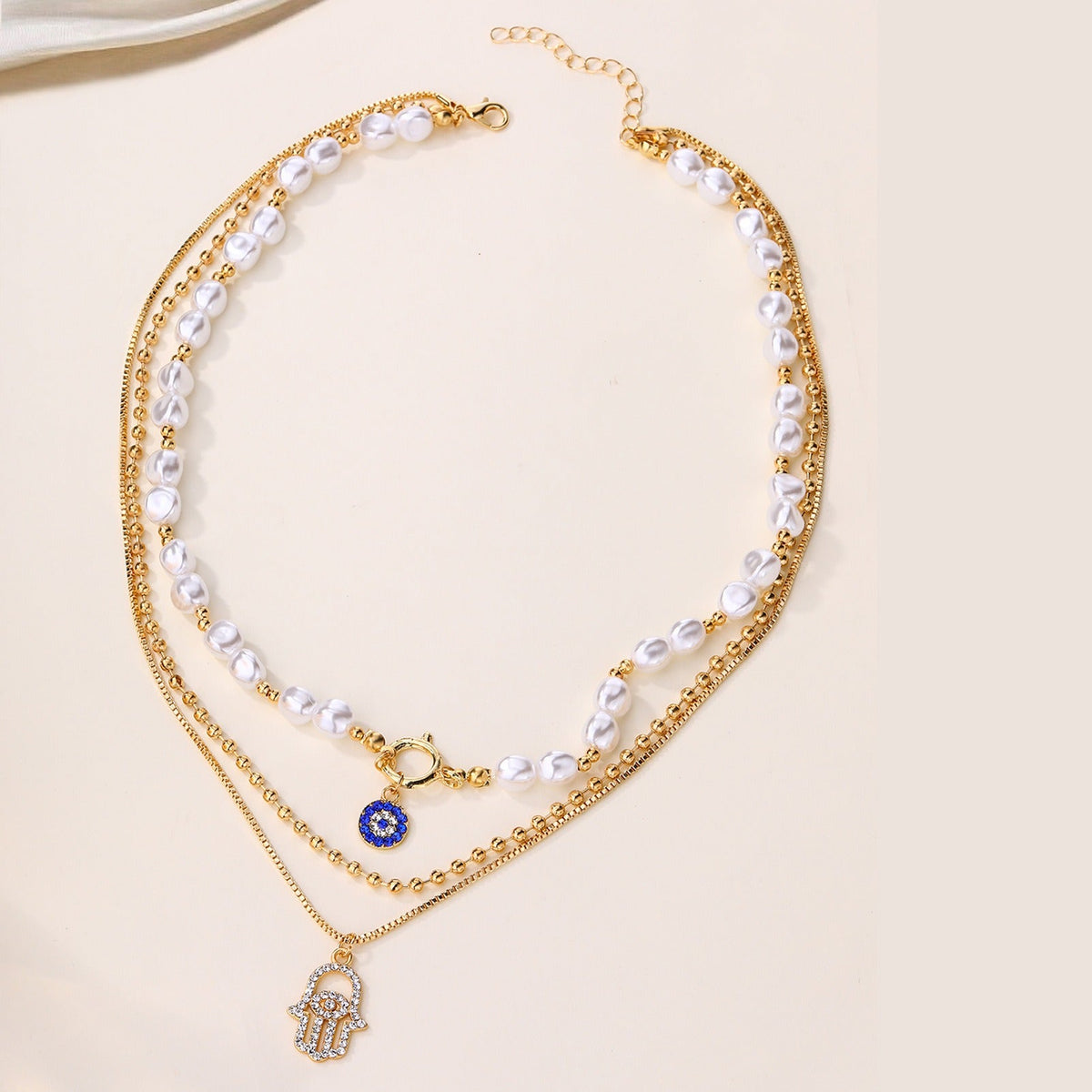 Jade – Collar de perlas en distintos niveles y Hamsa